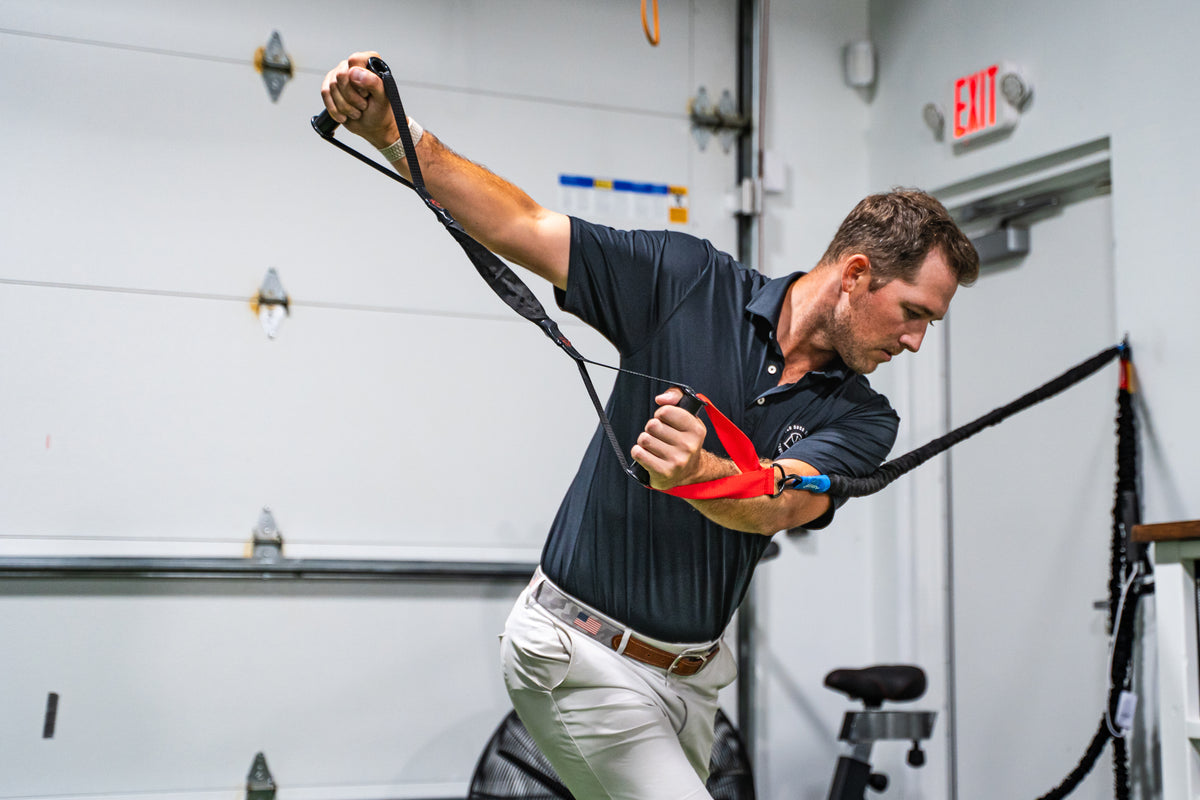 Pitcher arm-care bands and crossover symmetry prep at Boost Baseball.